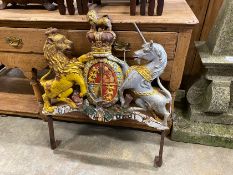 A Victorian painted cast iron Royal Coat of Arms, on later wrought iron stand, width 69cm, height