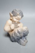 A Royal Copenhagen porcelain model of a seated faun, number 1736, 13cm tall