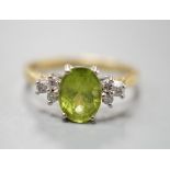 A modern 18ct gold and oval cut peridot ring, with diamond set shoulders, size M, gross weight 3