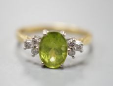 A modern 18ct gold and oval cut peridot ring, with diamond set shoulders, size M, gross weight 3