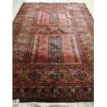 An Afghan style red ground carpet, 350 x 250cm
