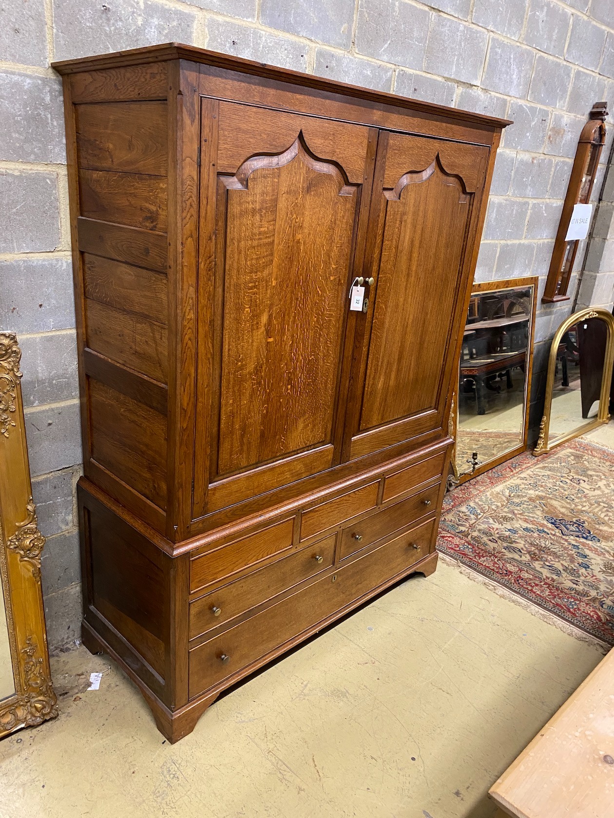 An 18th century and later panelled oak hanging cupboard fitted drawers, width 138cms, depth 56cms,