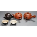 Two Japanese redware teapots, a similar brown stoneware teapot and two cups