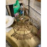 A pair of slatted wrought iron bowfronted three tier plant stands, larger width 82cm, height 63cm