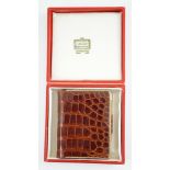 A boxed Cartier, London simulated crocodile notebook with silver pencil, unused, 8 cm.