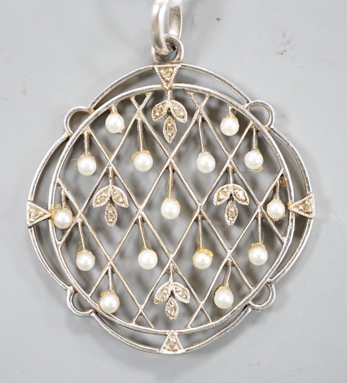 An early 20th century white metal, rose cut diamond chip and seed pearl set openwork pendant,