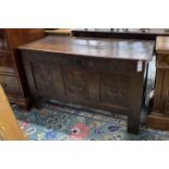 An 18th century carved panelled oak coffer, lid in two sections, length 115cm, depth 50cm, height