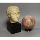 A simulated marble Roman head ornament, 24 cm and a rouge marble ball on stand, 15 cm