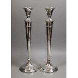 A pair of North American sterling candlesticks, with tapering stems, on circular bases, height 35.