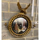 A Regency giltwood convex girandole wall mirror with eagle pediment, width 74cm, height 82cm