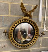 A Regency giltwood convex girandole wall mirror with eagle pediment, width 74cm, height 82cm