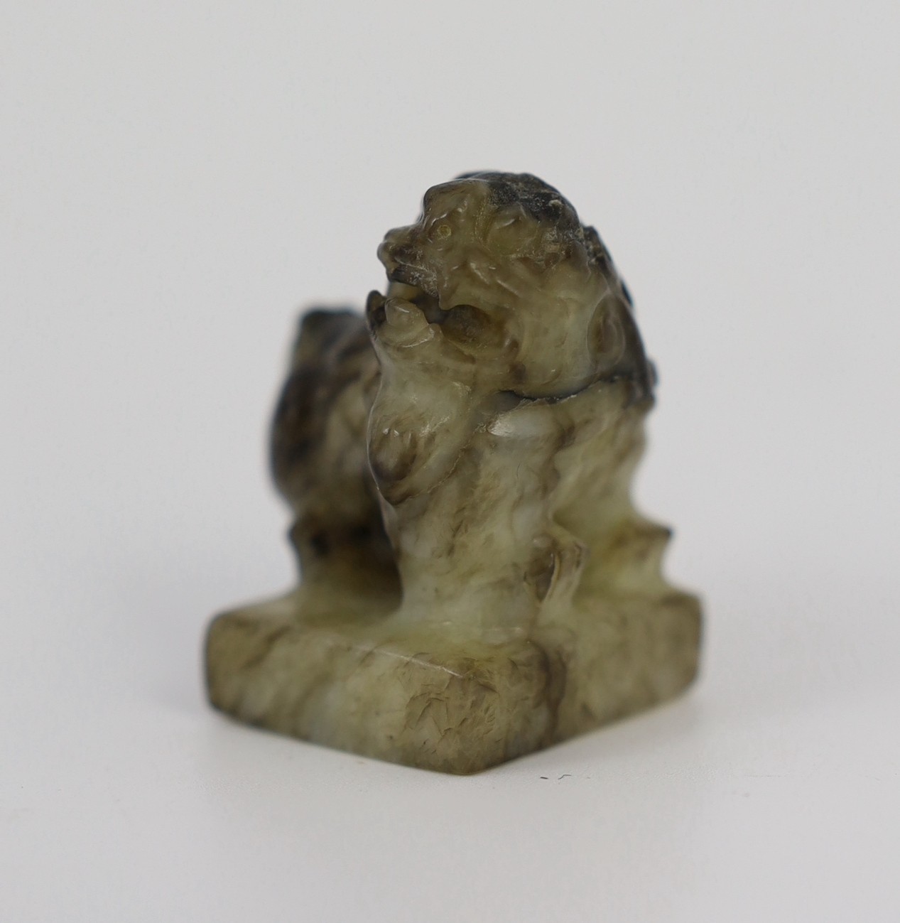 A Chinese pale celadon and black jade ‘lion-dog’ seal, 18th/19th century, the creamy white stone - Image 3 of 5