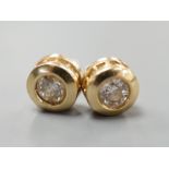 A modern pair of 14k yellow metal and single stone diamond set ear studs, with diamond chip setting,