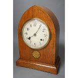 A pair of ebony rhinoceros book ends, together with an Edwardian oak lancet mantel clock, 35cm high