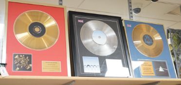 Three glazed framed award winning records: Pink Floyd, The Rolling Stones and Westlife