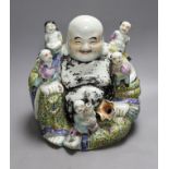 An early 20th century enamelled porcelain figure group of a seated Budai and children, 27.5cm high