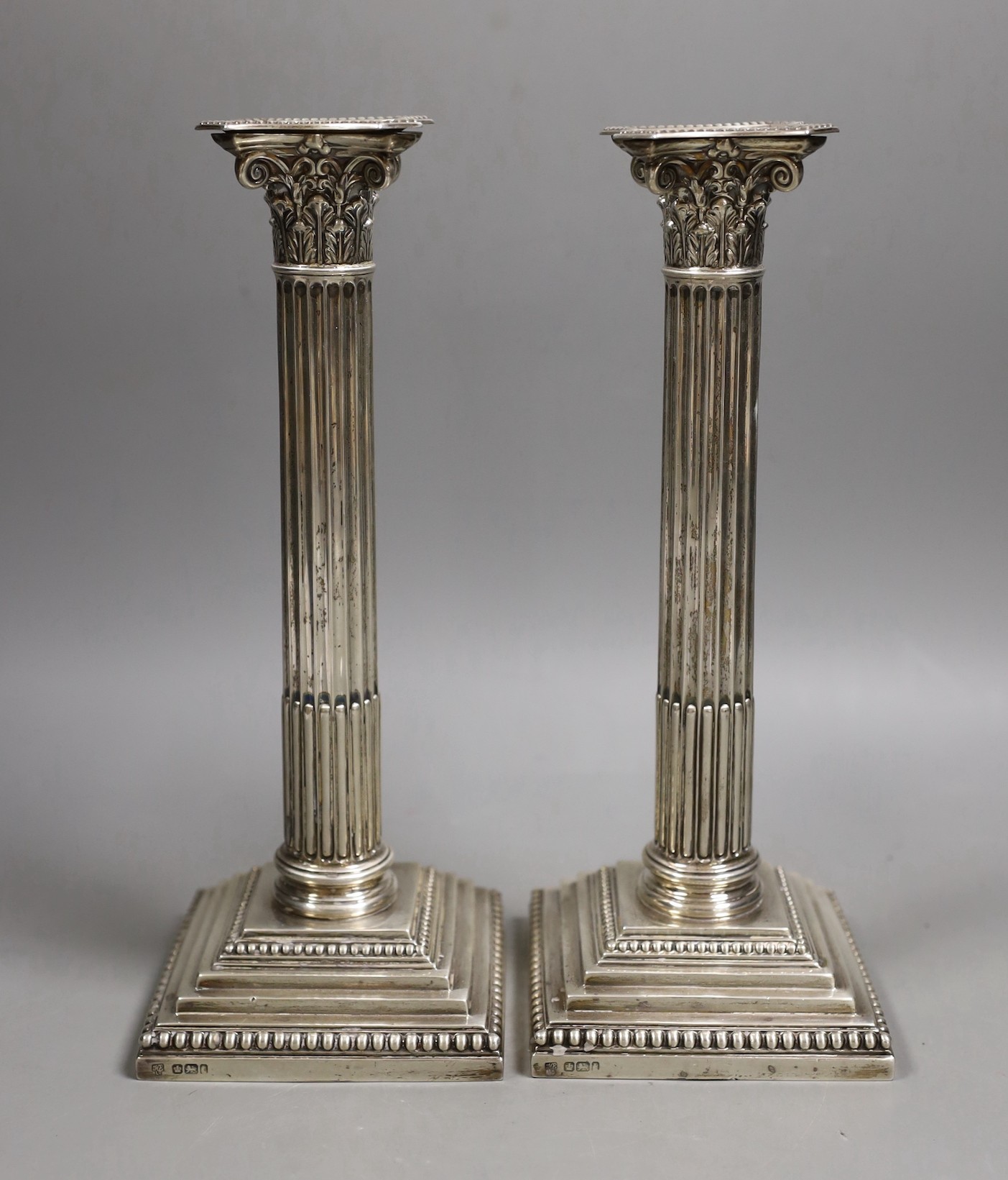 A pair of Edwardian silver Corinthian column candlesticks, Hawksworth, Eyre & Co, Sheffield, 1903,