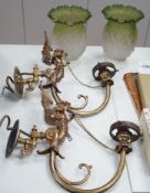 A pair of brass winged caryatid wall lights with green shades, 30cms deep