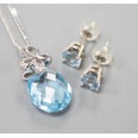 A modern 14k white metal, facetted pear cut blue topaz and diamond chip set pendant, 19mm, on a