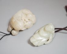 A Chinese pale celadon jade lion dog and cub and a similar figure of a boy, 19th/20th century