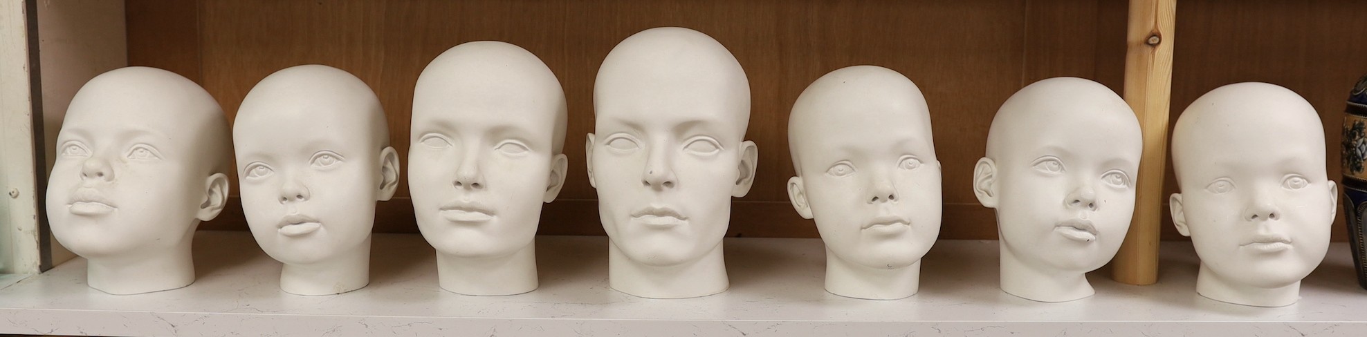 A set of seven fibreglass mannequin heads, largest 23cms high
