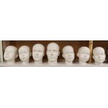 A set of seven fibreglass mannequin heads, largest 23cms high