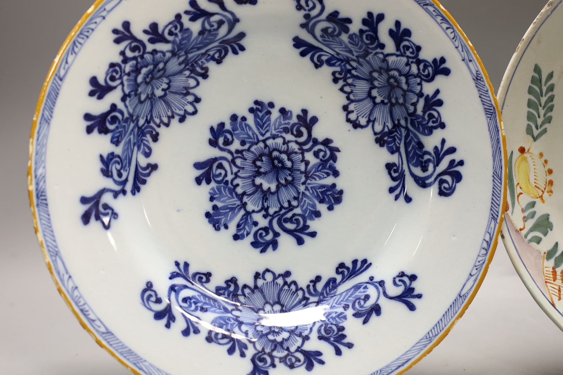 An early 18th century Delft polychrome dish and a mid 18th century Delft blue and white plate, - Image 2 of 4