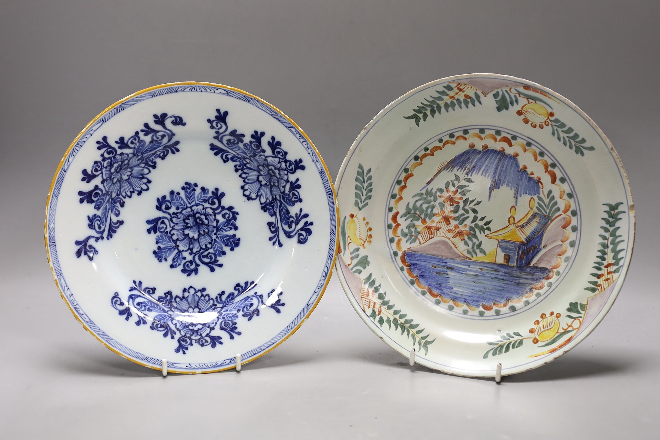 An early 18th century Delft polychrome dish and a mid 18th century Delft blue and white plate,