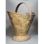 An embossed brass helmet coal bucket, 48cms high