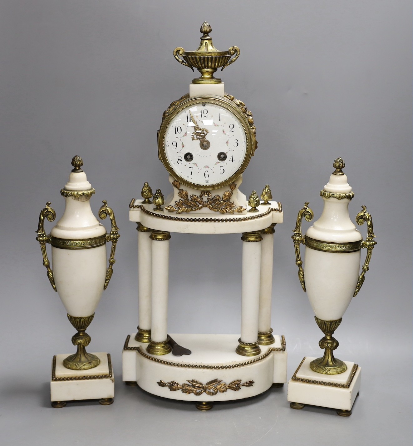 A Louis XVI style white marble and ormolu clock garniture, clock 47cms high