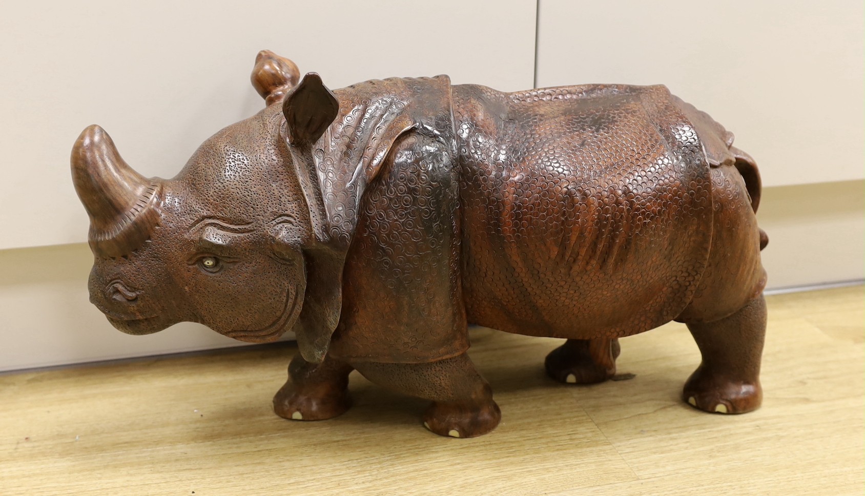 A carved wooden model of a rhinoceros, approximately 60cms long Ivory submission reference: