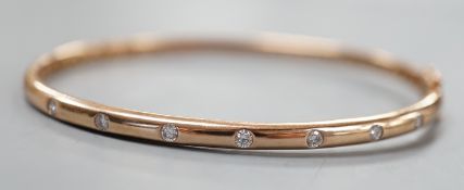 A modern 9k and nine stone gypsy set diamond hinged bangle, interior diameter 60mm, gross weight 9.3