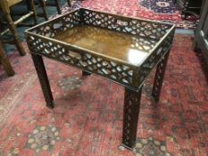 A George III pierced mahogany rectangular tray now as an occasional table on associated legs,
