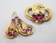 A Victorian yellow metal, oval and round cut garnet set demi parure, comprising a scroll work brooch