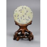 A Chinese jade disc and wood stand, 9cms high