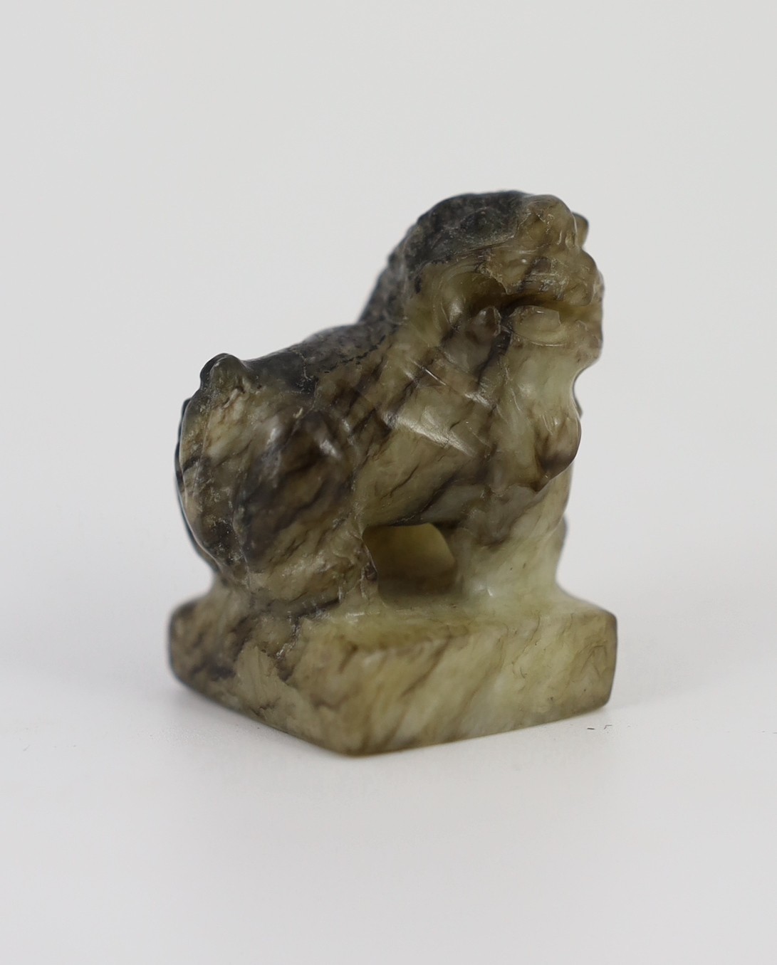 A Chinese pale celadon and black jade ‘lion-dog’ seal, 18th/19th century, the creamy white stone - Image 2 of 5