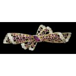 A mid to late 20th century pierced 18ct gold, ruby and diamond set ribbon bow brooch, with central