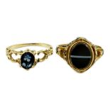 Two Victorian gold and chalcedony set mourning rings, one with oval banded agate, enamelled 'In