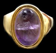 A Roman oval intaglio amethyst, carved with a figure with staff and pedestal, set in a later heavy