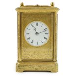A late 19th century French gilt brass repeating carriage clock, with floral scroll engraved case and
