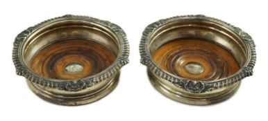 A pair of George IV silver mounted wine coasters by John Walton?, with gadrooned and scroll borders,