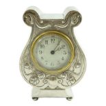 An Edwardian Art Nouveau silver cased mantle timepiece, of lyre shape, with Arabic dial and stylised