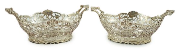 A pair of Edwardian pierced silver two handled bon bon dishes, by William Comyns, with floral scroll