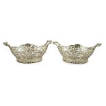 A pair of Edwardian pierced silver two handled bon bon dishes, by William Comyns, with floral scroll
