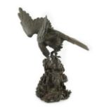 A Japanese bronze model an eagle standing on a rock, Meiji period, in two parts, incised five