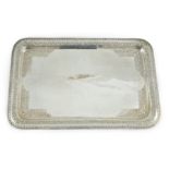 A 20th century Indian white metal rounded rectangular tea tray, embossed with birds amid scrolls,