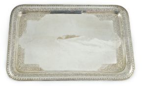 A 20th century Indian white metal rounded rectangular tea tray, embossed with birds amid scrolls,