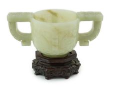 A Chinese archaistic celadon jade two handled cup, 17th century, carved in relief with archaistic