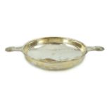 A George V Arts & Crafts planished silver two handled shallow dish, by Albert Edward Jones, the