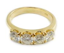 A modern 750 gold and four stone diamond set ring, each stone weighing approximately 0.30ct, size L,